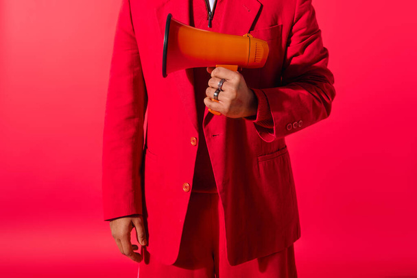 Knappe jonge Indiase man in rood pak met een megafoon. - Foto, afbeelding