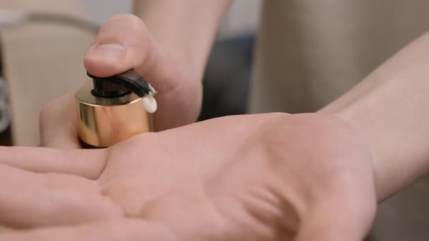 El hombre bombea crema de la botella a la palma cuidando de las manos de cerca. Guy utiliza productos naturales para el cuidado de la piel para mimar en casa. Procedimiento de belleza - Metraje, vídeo