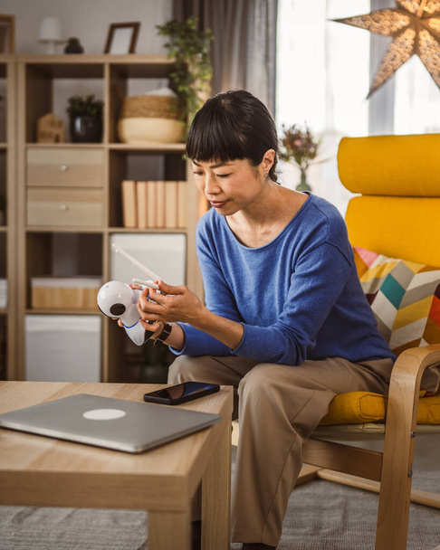 kypsä japanilainen nainen säätää valmistautua kotiin valvonta valvontakamera - Valokuva, kuva