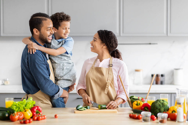 Африканська американська сім'я любить готувати їжу на сучасній кухні, з'єднуючись вдома, копіювати простір - Фото, зображення
