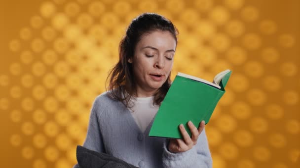 Vrouw worstelt om ogen open te houden tijdens het lezen van boek voor schoolexamen, zich uitgeput voelen, studio achtergrond. Moe student slaperig gevoel na het doen van huiswerk, hoofd op kussen, camera B - Video