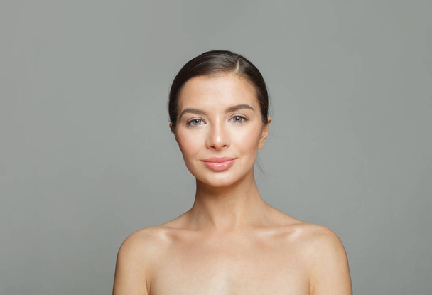 Κομψότητα υγιή γυναίκα μοντέλο με όμορφο δέρμα και χαριτωμένο χαμόγελο σε λευκό φόντο, στούντιο πορτρέτο. Θεραπεία προσώπου, φροντίδα δέρματος και κοσμετολογία έννοια - Φωτογραφία, εικόνα