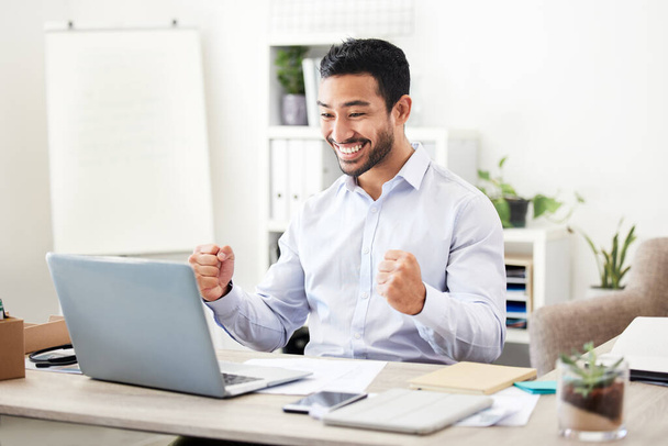 Business man, winner and laptop in office with stock market growth and financial success with fist. Happy, smile and investment profit with accounting promotion and excited professional at a desk. - Photo, Image