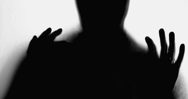 Σιλουέτα του ατόμου ακουμπά σε ομιχλώδες γυαλί, χέρια που πιέζονται στην απελπισία, ξεπεραστεί από την κατάθλιψη, έννοια της ψυχικής ασθένειας αισθάνονται απελπισμένοι και μόνοι κατά τη διάρκεια προκλητική φορές - Φωτογραφία, εικόνα