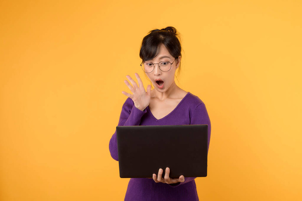 Mladá překvapená žena asijského etnika 30s nosit fialové tričko w - Fotografie, Obrázek