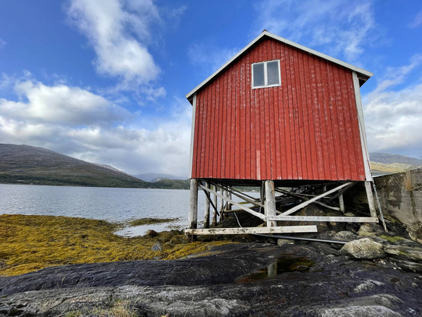stara typowa czerwona chata na szczudłach na brzegu morza w Szwecji Skandynawia  - Zdjęcie, obraz