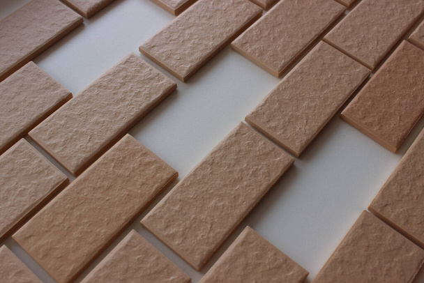 Zones manquantes sur la surface recouverte de rangées paires de carreaux muraux avec imitation maçonnerie - Photo, image