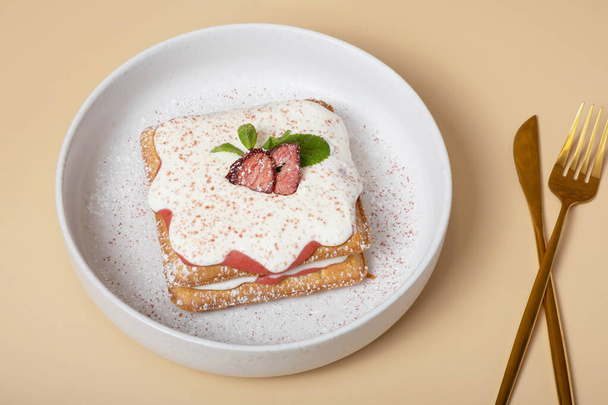 Bej arka plan görünümlü çilekli waffle ve krema soslu Belçika waffle 'ları. - Fotoğraf, Görsel