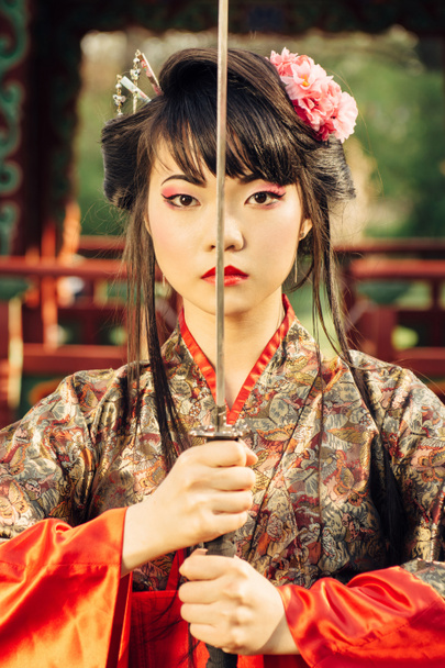 Beautiful geisha in kimono with samurai sword - Photo, Image