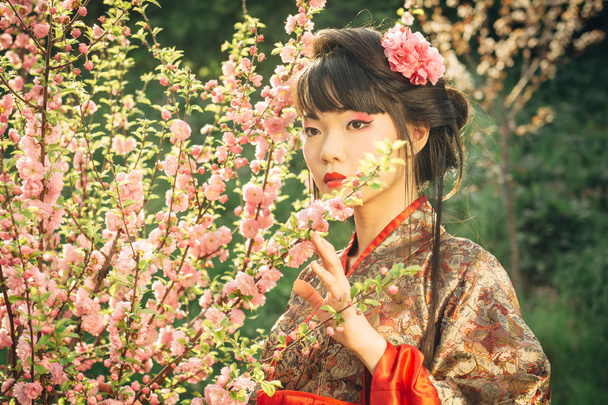 Beautiful asian woman in sakura blossom - Valokuva, kuva