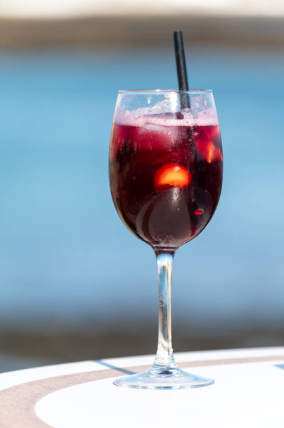 Glas koude sangria zoete wijn geserveerd met sinaasappel in strandcafé Corralejo, Fuerteventura, Spanje - Foto, afbeelding