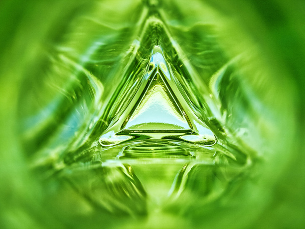 Abstraktní obraz uvnitř trojúhelníku skleněné láhve smaragdově zelené barvy pozadí - Fotografie, Obrázek