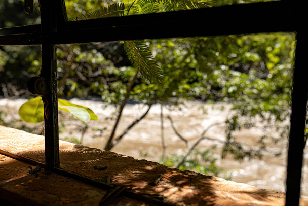 metaliczne okno ruiny z zamazaną rzeką w tle selektywne ustawianie ostrości - Zdjęcie, obraz