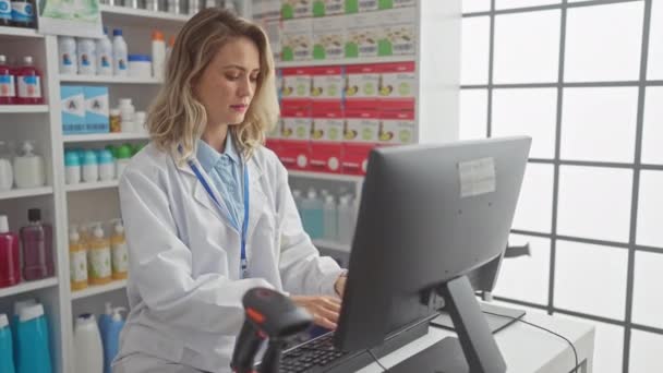 ブロンドの女性薬剤師は,薬やパーソナルケア製品を備えた棚を持つ現代の薬局でコンピュータで働いています.. - 映像、動画