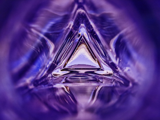 Imagen abstracta del interior de una botella de vidrio triangular color púrpura fondo
 - Foto, imagen