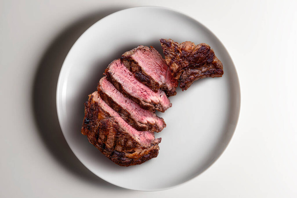 Beyaz arka planda izole edilmiş yuvarlak beyaz pirzola bifteğinin üst görüntüsü - Fotoğraf, Görsel