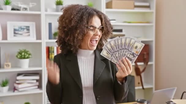 Innoissaan latino nainen kihara tukka ylpeänä nostaa dollareita, juhlii iloinen voitto ja onnistunut voitto toimistossa - Materiaali, video