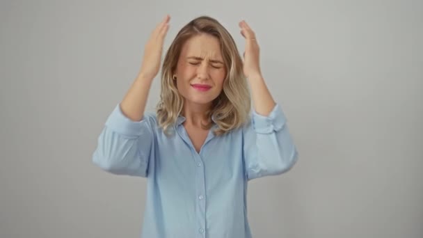 Depressieve jonge blonde vrouw in shirt, pijn van ernstige hoofdpijn geïsoleerd op witte achtergrond. gestresst met pijn, geconfronteerd met gezondheidsproblemen en spanning. - Video