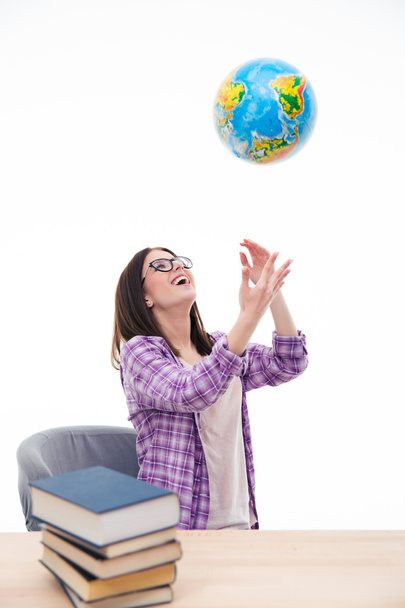Laughing female student throwing globe into air - Fotó, kép