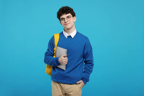 Portrait of student with backpack and tablet on light blue background - Φωτογραφία, εικόνα