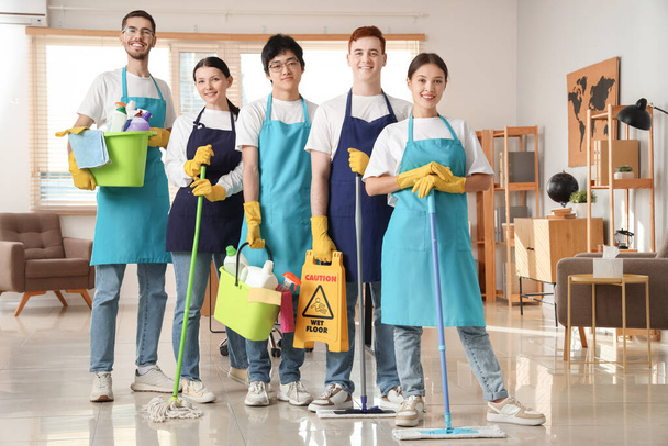 Group of young janitors with cleaning supplies in office - Photo, Image