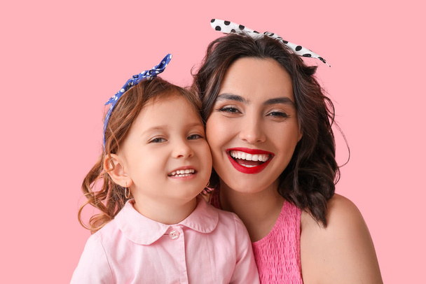 Happy pin-up woman and her daughter on pink background - Photo, Image