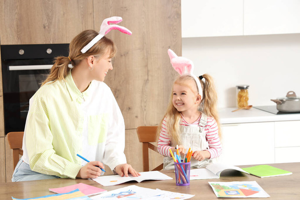 Nounou avec petite fille dans les oreilles de lapin dessin sur la table à la maison - Photo, image