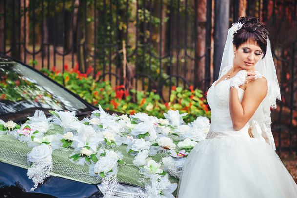 The bride near a black wedding car - Foto, imagen