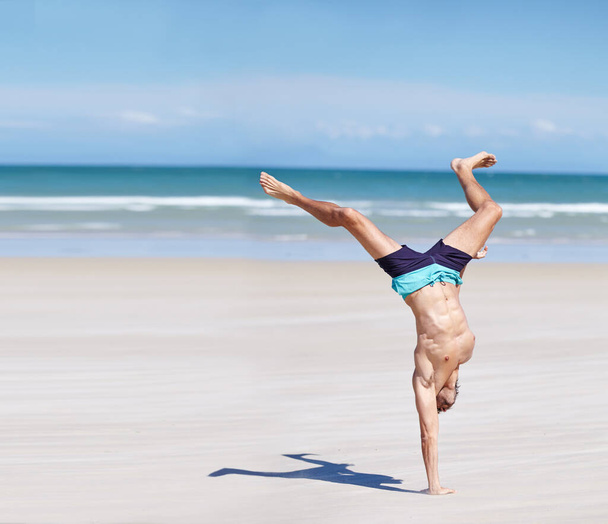 Άνθρωπος, γυμναστική και σώμα στη θάλασσα για άσκηση με το καλοκαίρι, υγεία και ευεξία. Άνδρας αθλητής, ωκεάνιο νερό και δραστηριότητα για αθλητικές προπονήσεις με ήλιο, δυνατούς μυς και χέρι στην παραλία του Κέιπ Τάουν. - Φωτογραφία, εικόνα