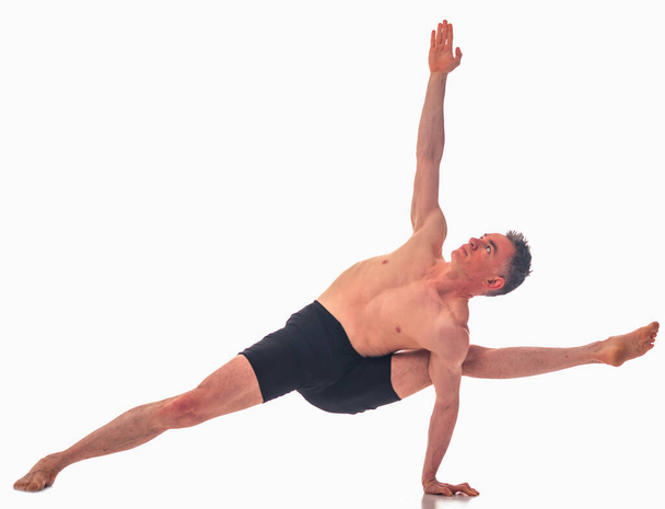 Visvamitrasana, Ashtanga jóga Boční pohled na muže ve sportovním oblečení dělá jóga cvičení na bílém pozadí.  - Fotografie, Obrázek