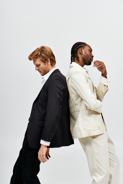 Két multikulturális férfi elegáns öltönyben egymás mellett pózol.. - Fotó, kép