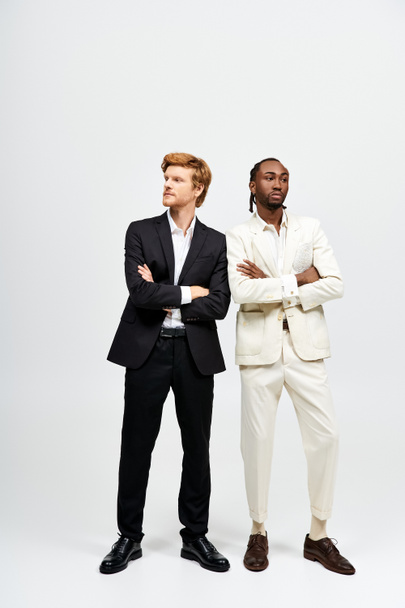 Zwei gutaussehende multikulturelle Männer in eleganten Anzügen stehen zusammen. - Foto, Bild