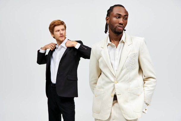 Két multikulturális férfi elegáns öltönyben, magabiztos pózban.. - Fotó, kép