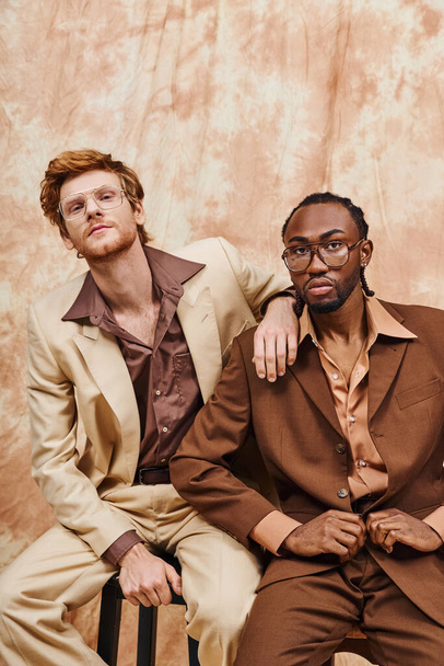 Zwei multikulturelle Männer mit elegantem Stil sitzen zusammen. - Foto, Bild