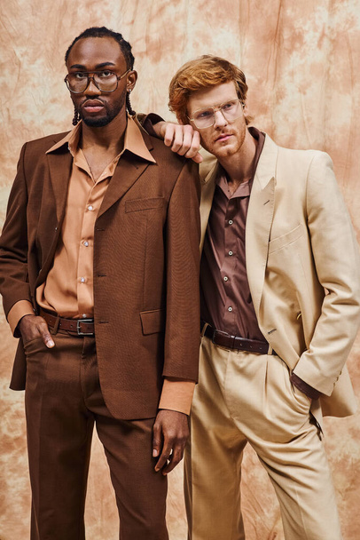 Zwei elegante, multikulturelle Männer in schicken Anzügen stehen nebeneinander. - Foto, Bild