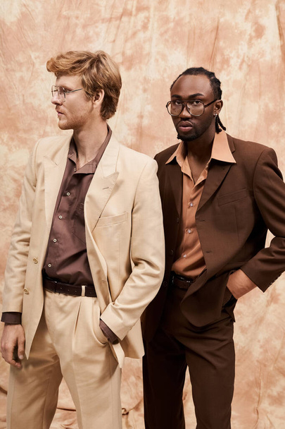 Dos hombres multiculturales en elegante estilo elegante están uno al lado del otro frente a una pared. - Foto, imagen