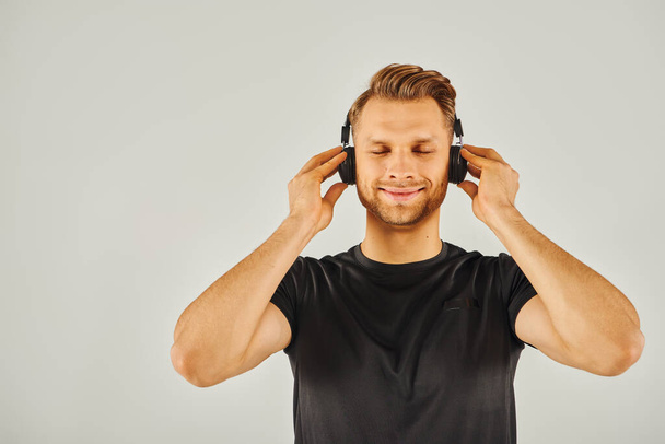 Un hombre inmerso en su propio mundo, escuchando música a través de auriculares. - Foto, imagen