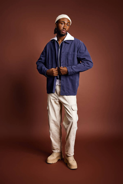Komea nuori afroamerikkalainen mies sinisessä takissa ja valkoisissa housuissa.. - Valokuva, kuva