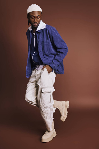 Un bel homme afro-américain vêtu d'une veste bleue et d'un pantalon blanc. - Photo, image