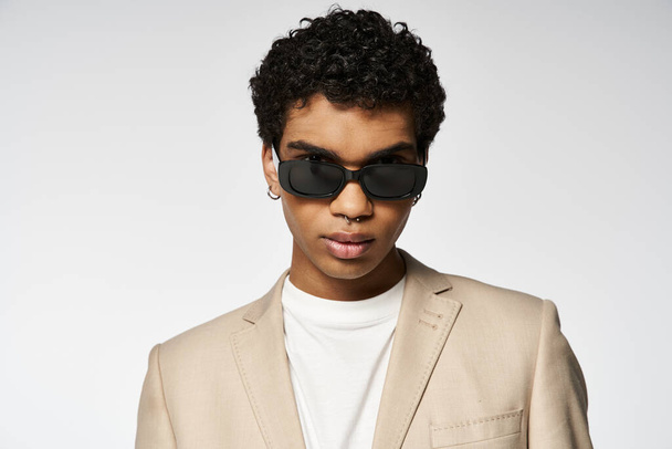 Hombre afroamericano guapo en gafas de sol y traje de bronceado. - Foto, Imagen