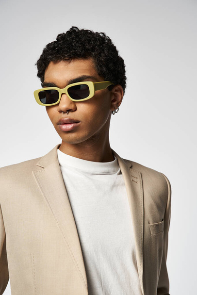 Dapper homme afro-américain en costume bronzé et élégantes lunettes de soleil jaunes. - Photo, image