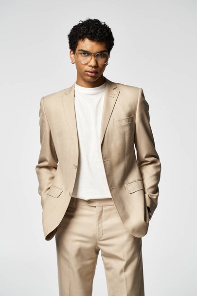 Stilvoller Mann im braunen Anzug posiert selbstbewusst mit Sonnenbrille. - Foto, Bild