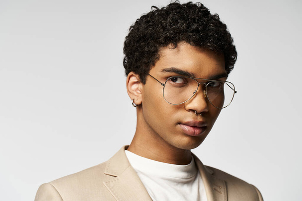 Jóképű afro-amerikai férfi barna öltönyben és stílusos szemüvegben.. - Fotó, kép