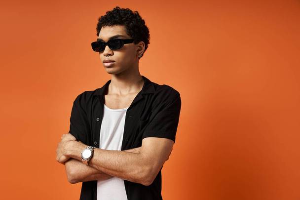 Handsome African American man in stylish sunglasses against bright orange backdrop. - Photo, Image