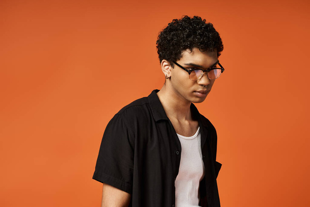 Beau Afro-Américain dans des lunettes sur fond orange vif. - Photo, image