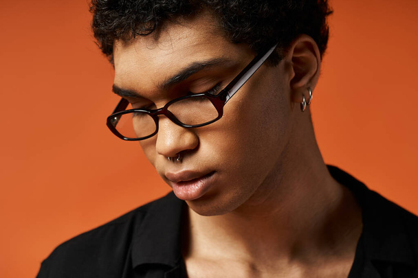 Афроамериканец в очках на ярком оранжевом фоне. - Фото, изображение