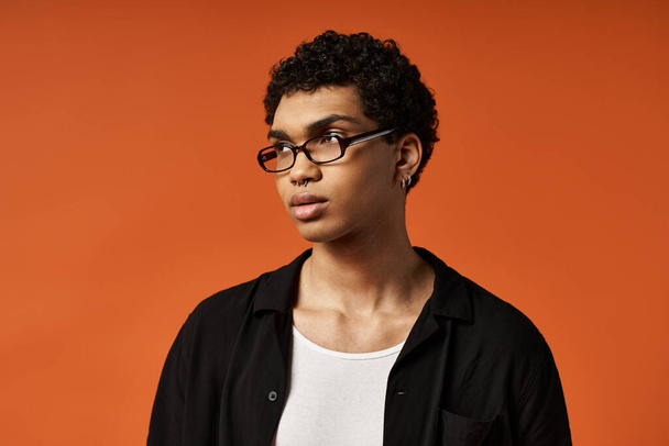 Schöner afroamerikanischer Mann mit stylischer Brille vor leuchtend orangefarbenem Hintergrund. - Foto, Bild