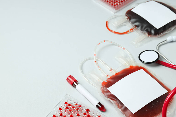 Tašky a zkumavky s dárcovskou krví na bílém pozadí, prostor pro text - Fotografie, Obrázek
