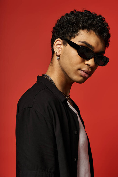 Jóképű fiatalember napszemüvegben és fekete ingben.. - Fotó, kép