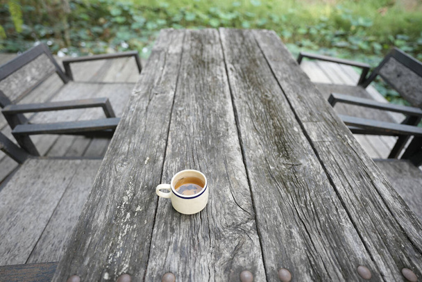 Κύπελλο τσαγιού σε grunge ξύλινο τραπέζι υπαίθρια πόσιμο - Φωτογραφία, εικόνα